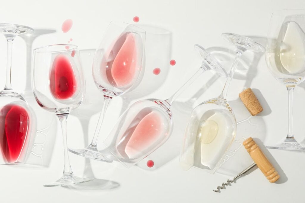 Wines of different shades from dark to light in glasses.