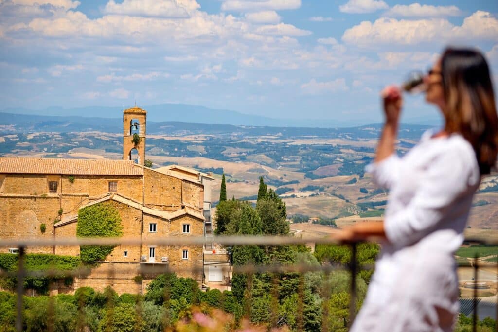 A woman drinking red wine in Montalcino, Tuscany in Italy.