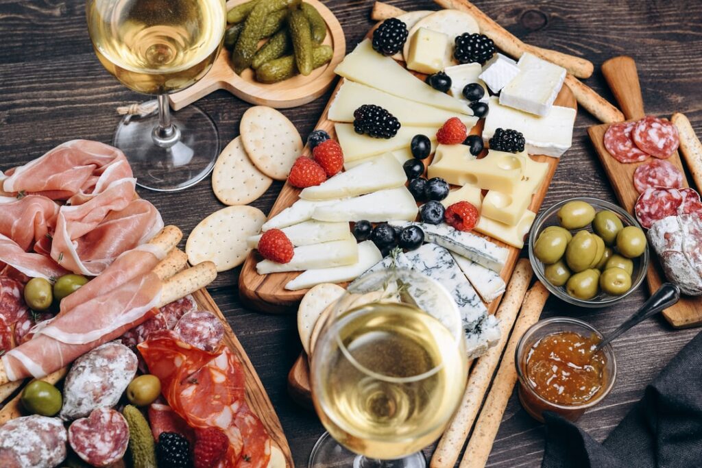 Wine tasting charcuterie board with salumi, cheese, fruit, olives, and bread.