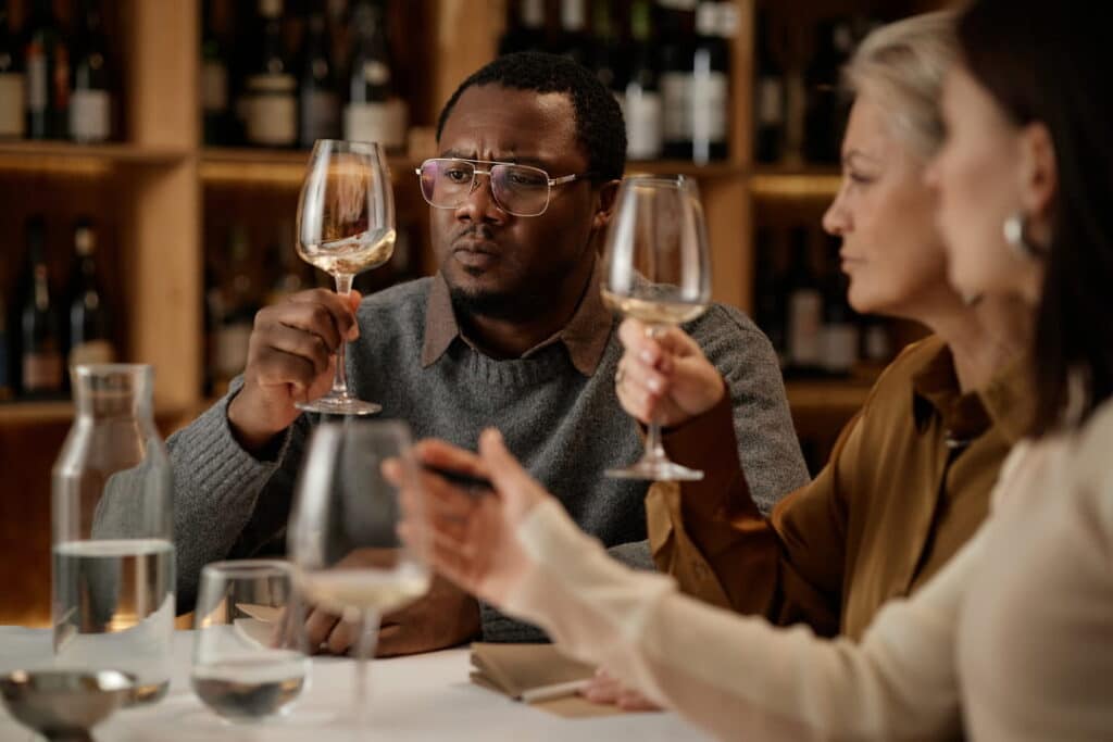 Group of people looking at color of wine in a glass during a wine tasting