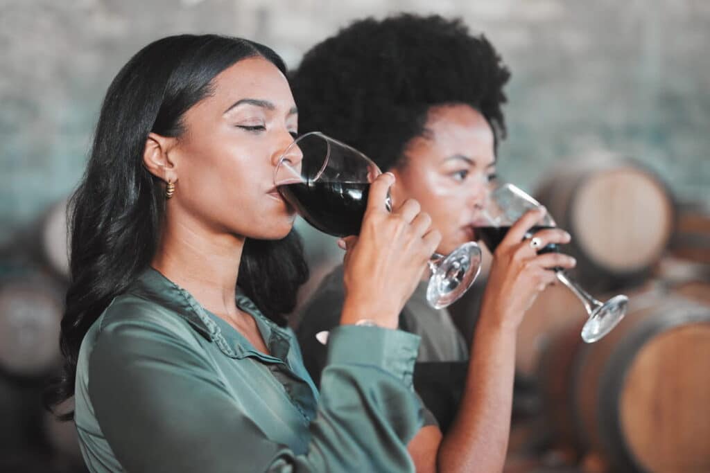 Women sipping wine at wine tasting.